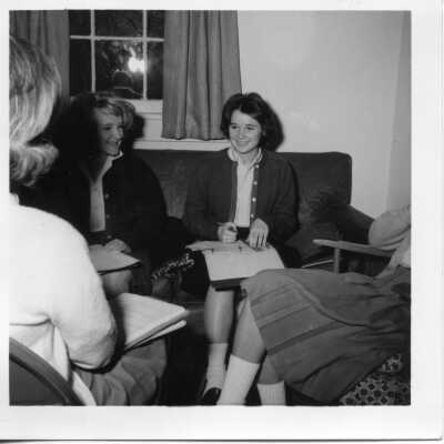 Students sitting on sofa with notebooks in 1963.