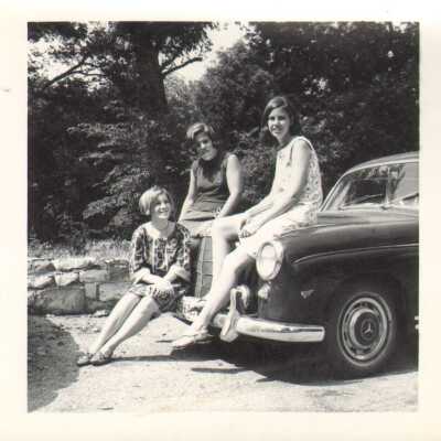 Students pose by a car, 1960s