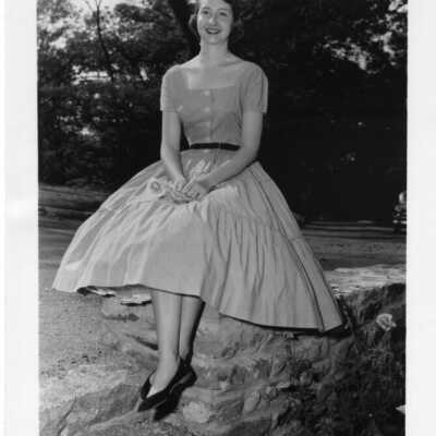 Polly Armistead sitting on stone wall.