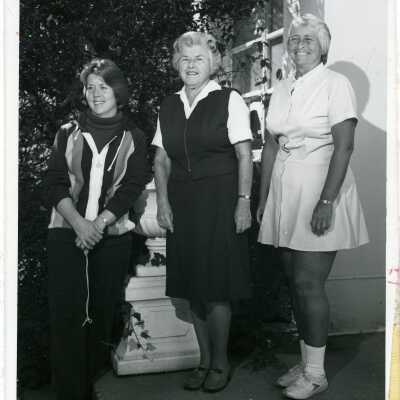 Three women standing outside of a building