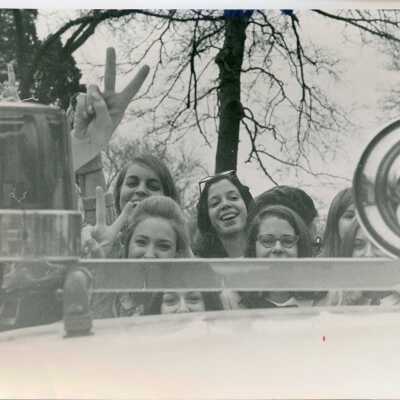 Students pose in a police car, 1960s