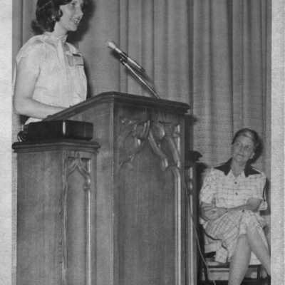 Student at podium in auditorium during assembly circa 1960's.