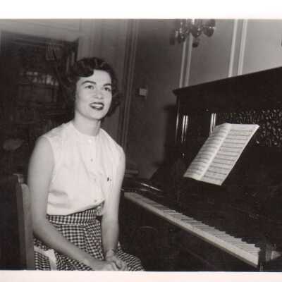 Student poses at a piano, 1960s