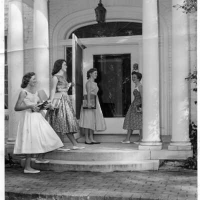 Four students carrying books on the front steps of Souby Hall.