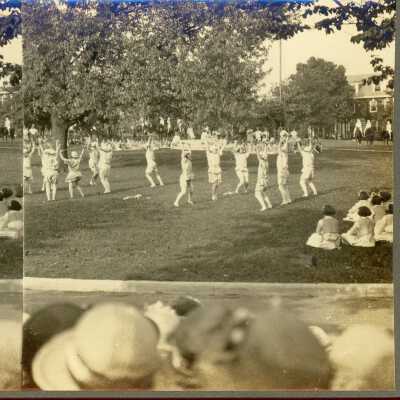 Belmont College for Women, circa 1910, women in white clothing performing on the lawn with onlookers.
