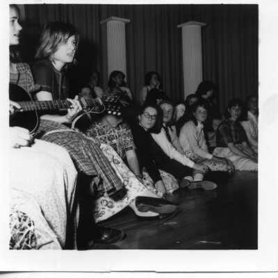 Student playing guitar for other Students