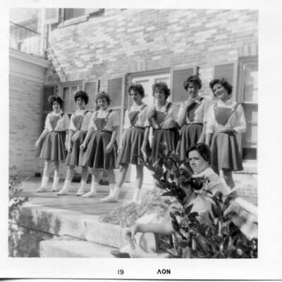 Students standing on the back of Souby with some kind of uniform on that may be cheerleading or some club uniform.