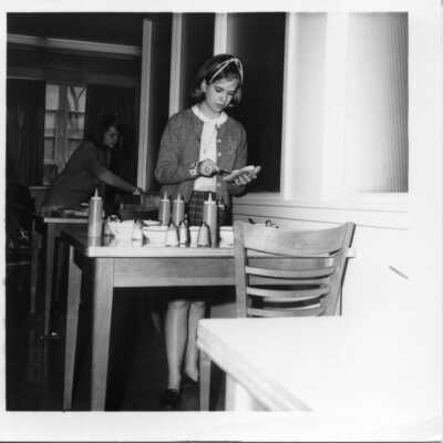 Student making a hot dog in the cafeteria circa 1960's.