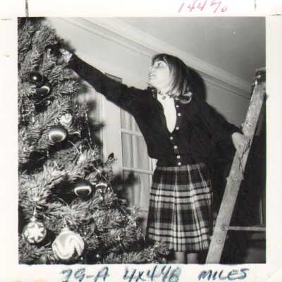 Student decorates tree, 1960s