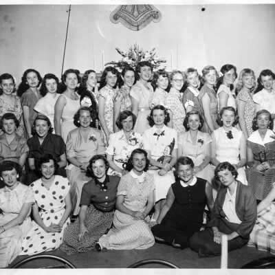 34 girls in nice dress inside a building. Probably a club picture from Ward-Belmont School.