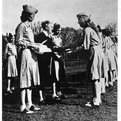 Mary Elizabeth Cayce and Ms. Catherine Morrison. Girls appear to be wearing military-style khaki uniforms with hats and saddleback shoes.
