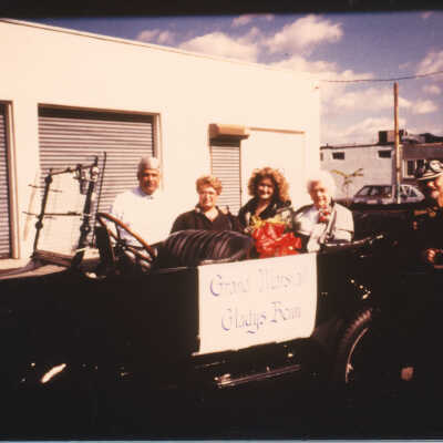 Grand Marshall Gladys Benn in the 1916 convertible she rode in for the parade. The owner of the car, Bill Brigiani, is at the right with the goggles. Others pictured are unidentified.