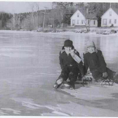 Boys sledding on Harrisville Pond ice