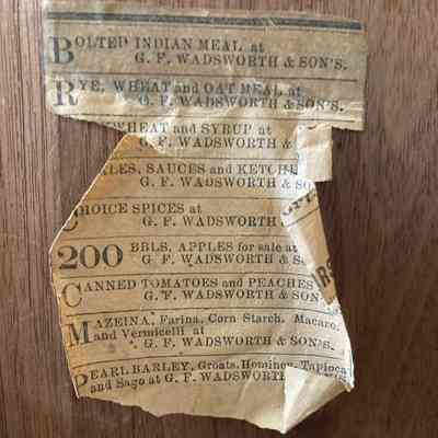 Newspaper clipping inside door to side cabinet on top of desk.