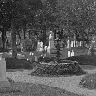 Photograph showing fountain in its original location near the rear of east side of Hillside Cemetery in Eastport, Maine. Masonic Tombs can be seen at the far left of the photograph. Photograph dates to about 1900.