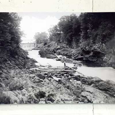 Photograph Postcard of the Saco River at Salmon Falls, late 19th century Gibeon E. Bradbury Family Papers, Dyer Library and Saco Museum Archives: Although the bridge shown in this postcard is slightly different than the one depicted in the painting, on both cases the scene is one of a log drive. Note that in both views there is a river driver perched on the logs in the middle of the river.
