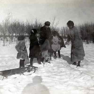 Group of Unknown Women and Children Playing in the Snow with a Sled