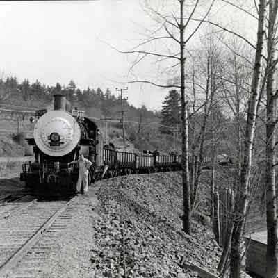 Train Pulling Cars of Logs along River - Engine #2526