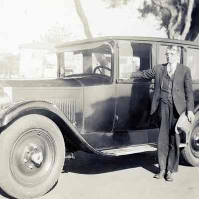 Unknown Man Standing Next to a Model A Sedan
