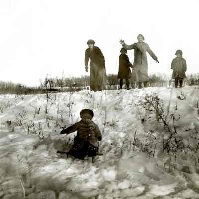 Group of Unknown Women and Children Playing in the Snow with a Sled