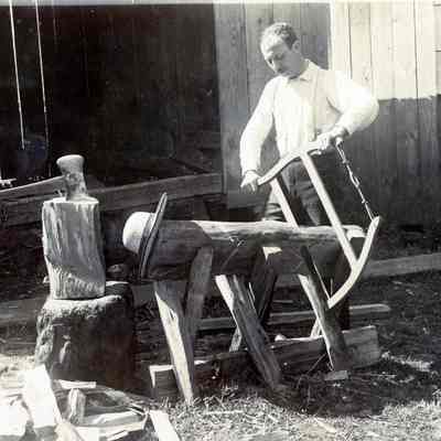 Unknown Man Sawing and Chopping Wood