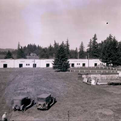 Field with two cars and buildings in background - No Date - Negative