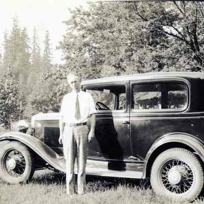 Unidentified Man Standing next to a Model A Sedan