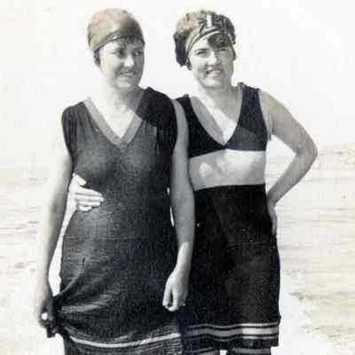 Two Women in Bathing Suits Standing in the Surf