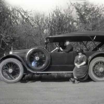 Couple Seated in Car with Woman on Running Board.