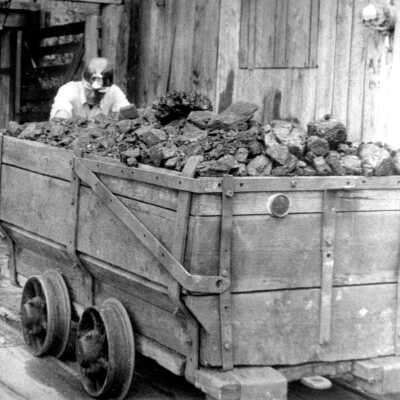 Theodore (Ted) Mandrones pushing ore cart from his mine.
