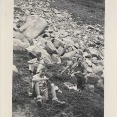 4 Persons Sitting on Rocks
