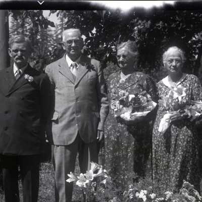 Two Women and Two Men Holding Flowers.
