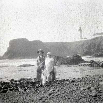People and Lighthouse at Beach.