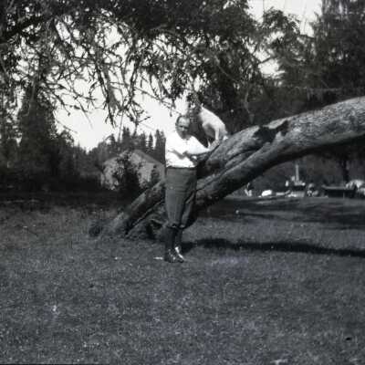 Man with Dog Leaning Against Tree.