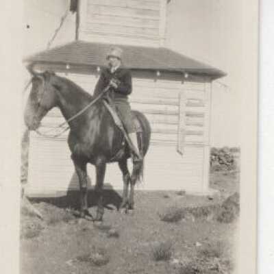 Unknown Woman on Horse in Front of Building