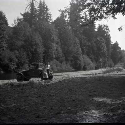 Man and Woman with Car at Riverside.