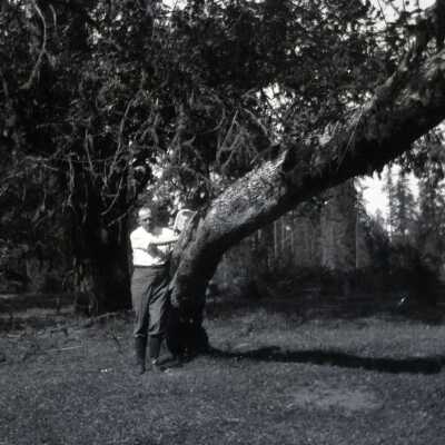 Man Leaning Against Tree.