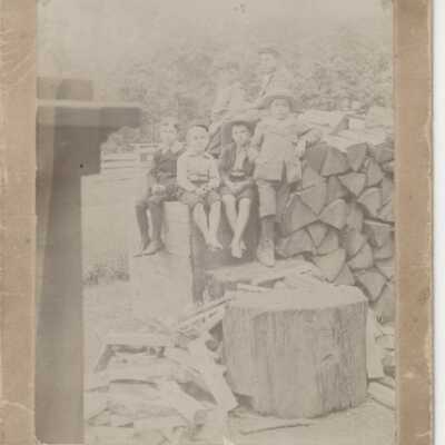 Children sitting on a stack of firewood