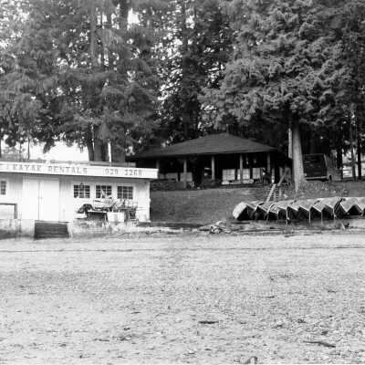 Canoe and Kayak Rentals Building with log cabin in background, before demolition