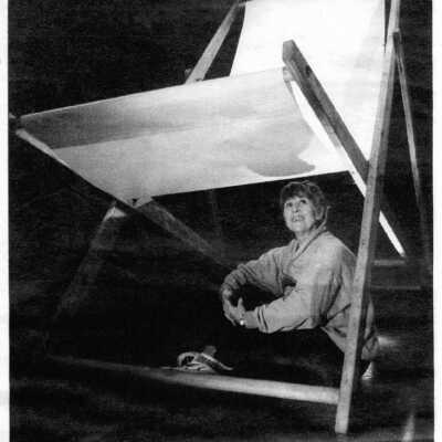 Gigantic to Miniature show photo. Curator Carole Badgley under Ilze Bebris folding chair.