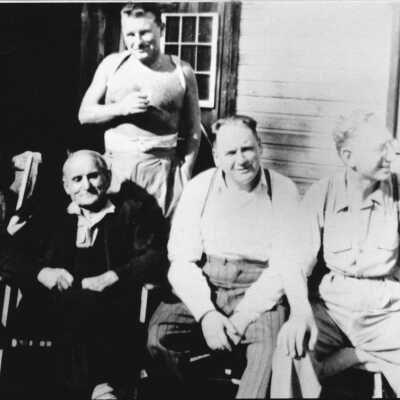 Malcolm Lowry standing outside his shack with friends