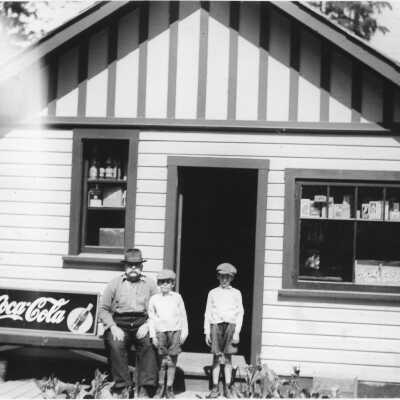 Moore by store with sons, Tom & Jim