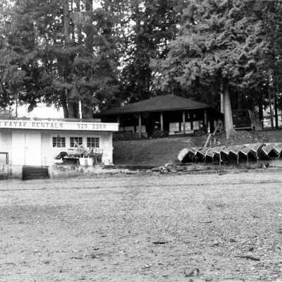 Cove Canoe and Kayak Rentals with log cabin in background, before demolition
