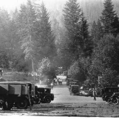 Old cars and people on dirt road