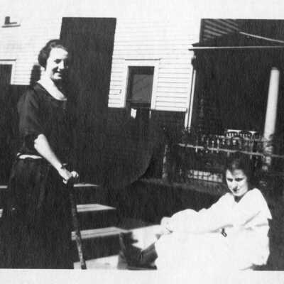 Two Women in Front of House