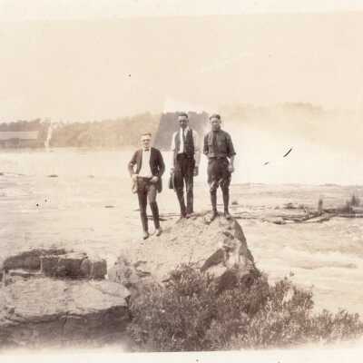 Three Men Standing on Rock