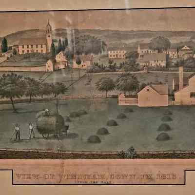 A painting of Windham showing a field with houses on rolling hills in the background.: The same image as seen above but edited for clarity of picture. Frame out of view. 
A lithograph of Windham, Connecticut. In the foreground of the picture is a field with several farmers working to bale hay. In the upper right corner of the field is a white farmhouse. Beyond the farmhouse, a town sits on rolling hills displaying a church at the highest part of the town. At the bottom of the lithograph is the text "View of Windham Conn. in 1815" Below that, smaller print notes that this view is from the east.