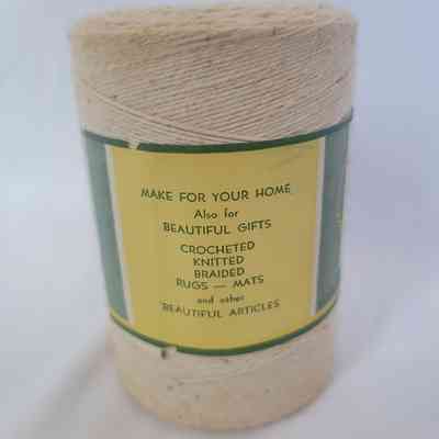 A spool of beige thread with a label for home crafting, gifts, and making rugs or mats.