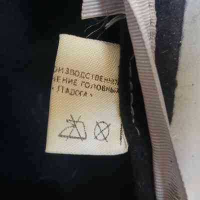 The image shows a fabric tag with care symbols and some text in Russian