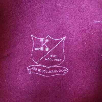 The image shows a maroon felt fabric with a white printed logo, stating "100% Wool Felt